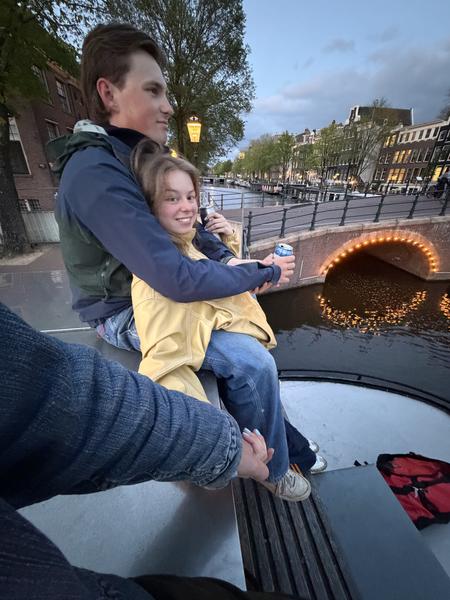 A man and a child riding a boat along a canal in the evening